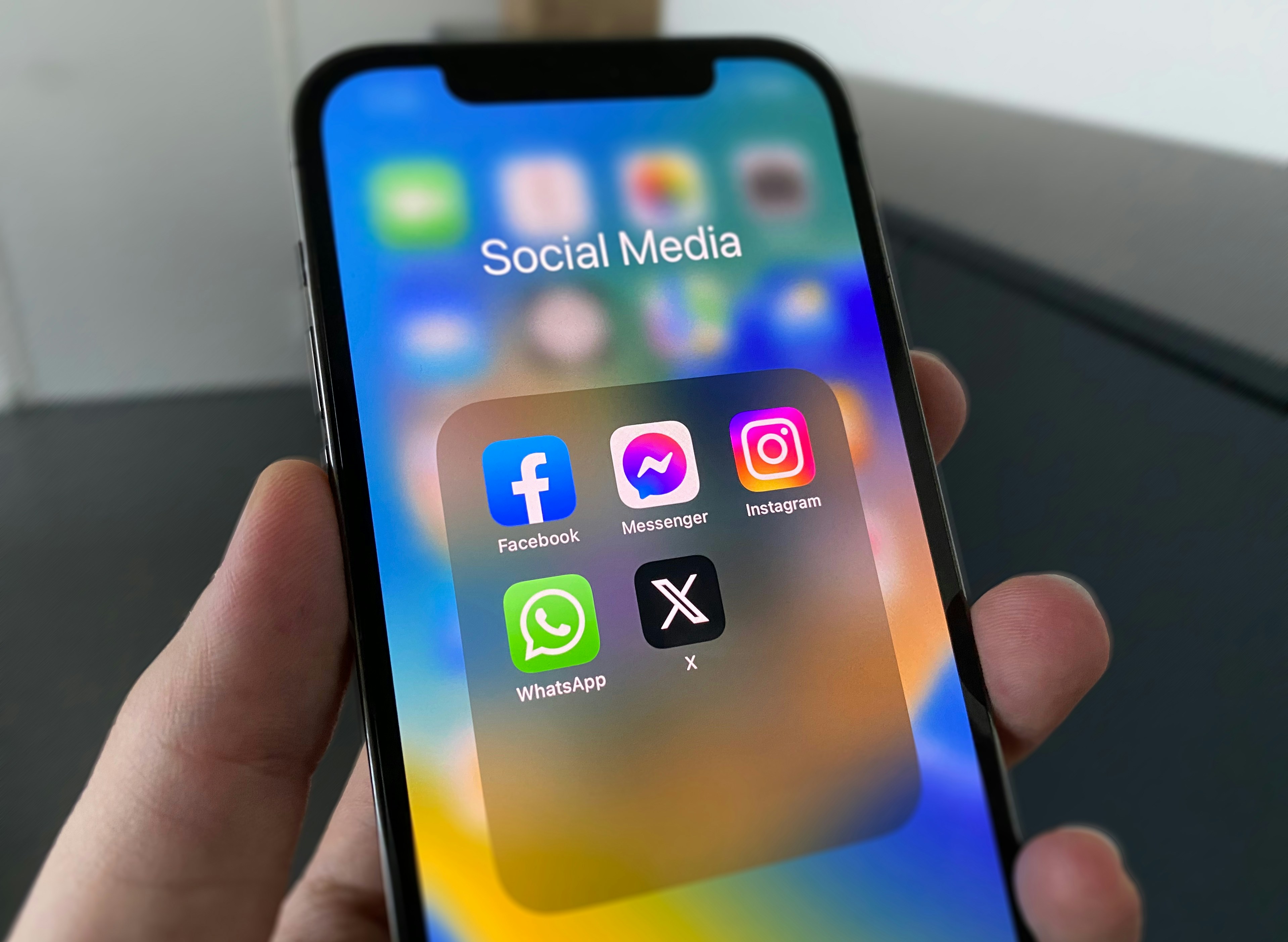 Person hält ein Smartphone mit mehreren Social-Media-Apps auf dem Display